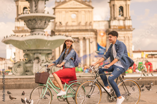 Portrait of young Latin couple with bikes in a downtown park. photo