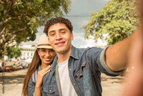 Happy Latino tourists taking photos of themselves. Taking a selfie with a smartphone.