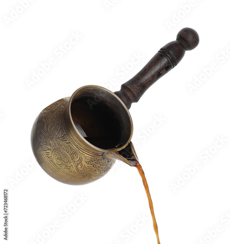 Turkish coffee. Pouring brewed beverage from cezve on white background photo