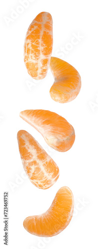 Pieces of fresh ripe tangerine falling on white background