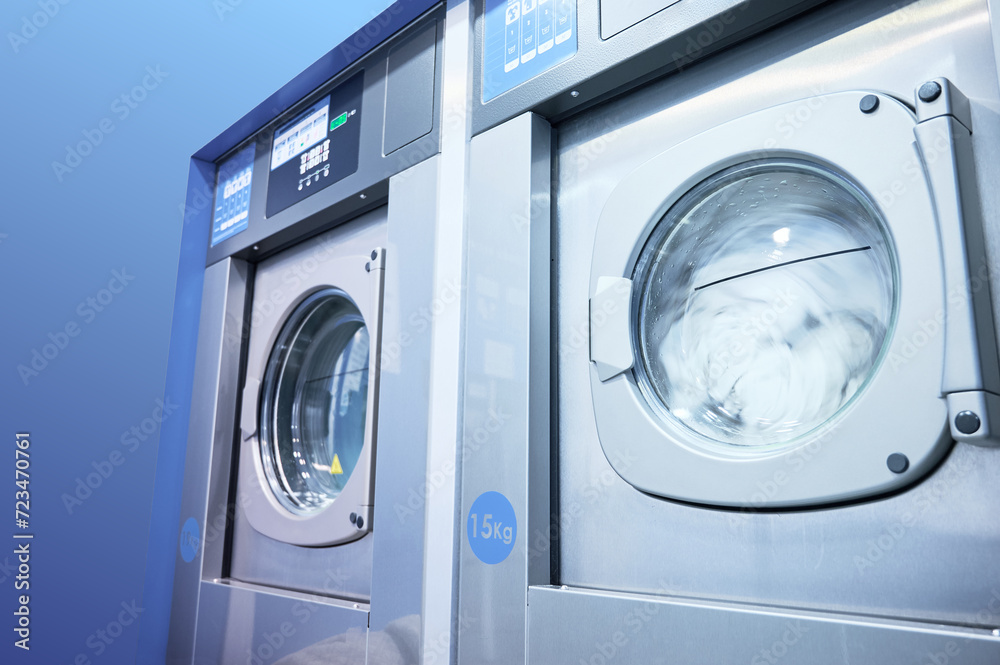 Inside a laundry service bussiness. High load automatic industrial washing machines working. Inside a laundry service bussiness. High load automatic industrial washing machines working.