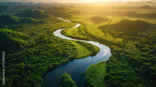 Aerial view of a meandering river through a lush  green valley at sunset