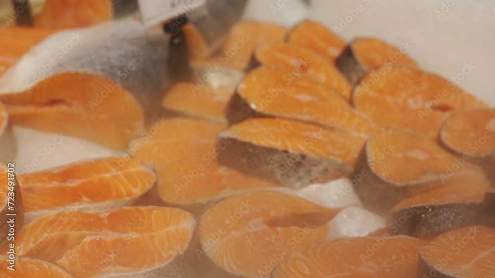 Pieces of raw steak from fresh salmon lying on the ice counter at the fish market. Pieces of raw steak from fresh salmon lying on the ice counter at the fish market.