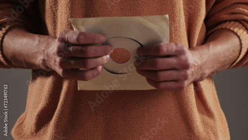 Retro Vinyl records in man hands close-up macro. Old disck for music. Retro vintage music player at home photo