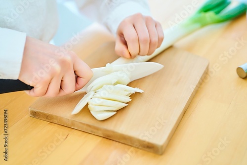 包丁で食材を切る若い女性