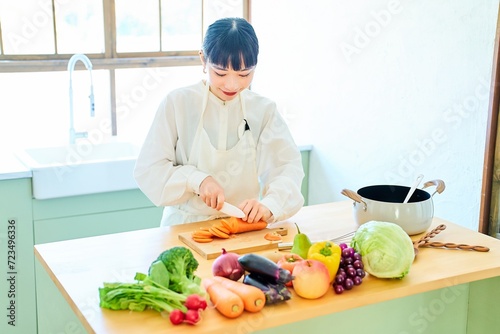 包丁で食材を切る若い女性