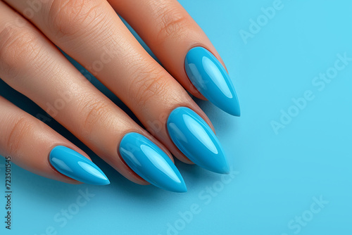 Female hand with manicure on blue background close-up.