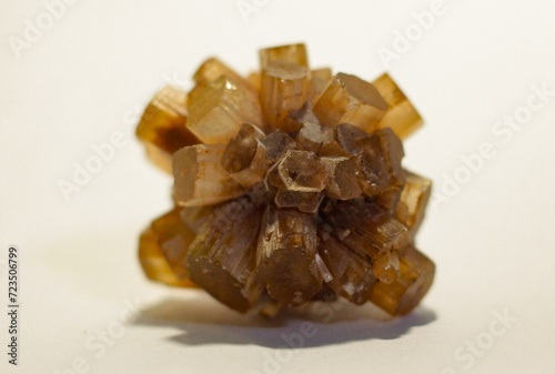 Natural Rough Orange Aragonite Metaphysical Healing Crystal Gemstone Mineral Starburst Cluster Formation on Light Background with Shallow Depth of Field Warm Tones
