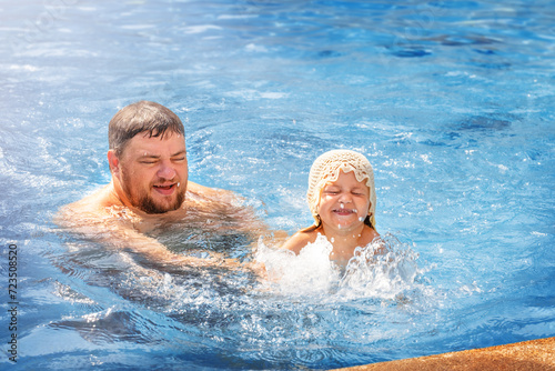 Dad teaches daughter to swim in the pool