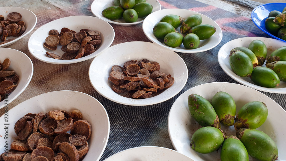 A selection of fresh and dried betel nut, areca nut, displayed in bowls at a local market stall in West Papua, Indonesia A selection of fresh and dried betel nut, areca nut, displayed in bowls at a local market stall in West Papua, Indonesia