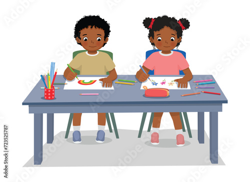Cute African kids students drawing picture at the table together
