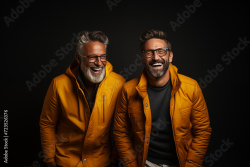 Two laughing mature friends  in yellow jackets © Bhanuka