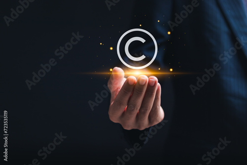 Copyright or patent concept, copyleft trademark license. Businessman holding virtual copyright symbol for author rights and patented intellectual property. photo