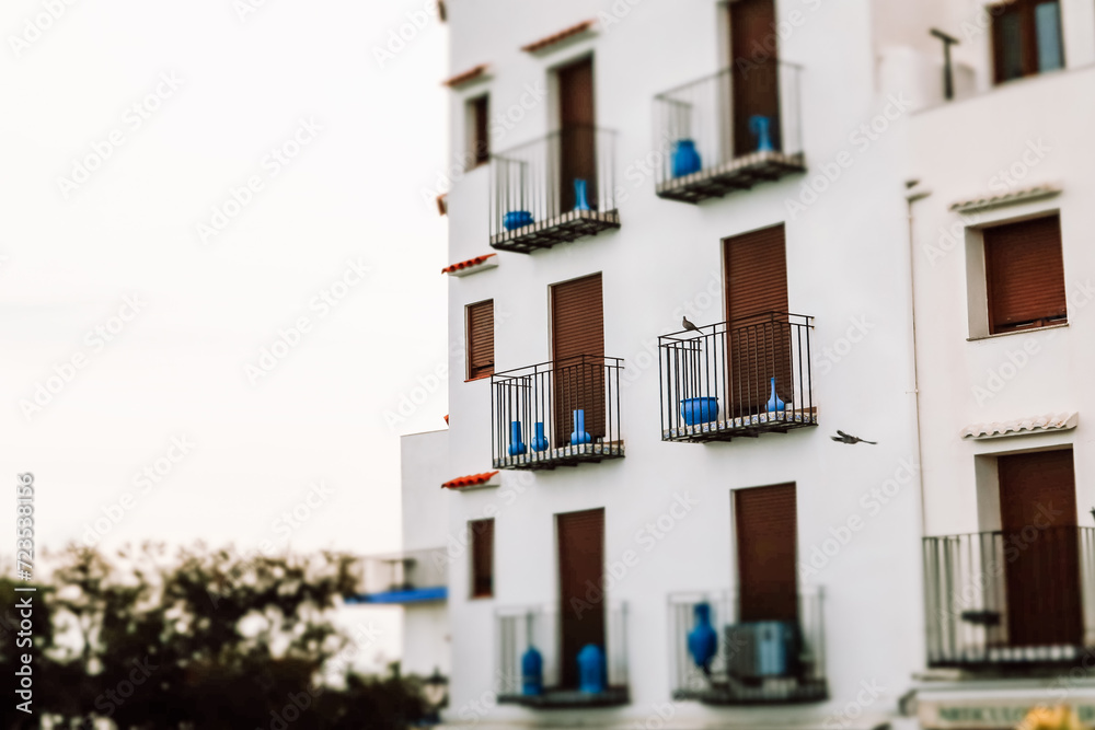 White hotel building on the edge of a cliff against a blue sea. A holiday dwelling with seascape view. Travel destination. Summer vacation postcard.