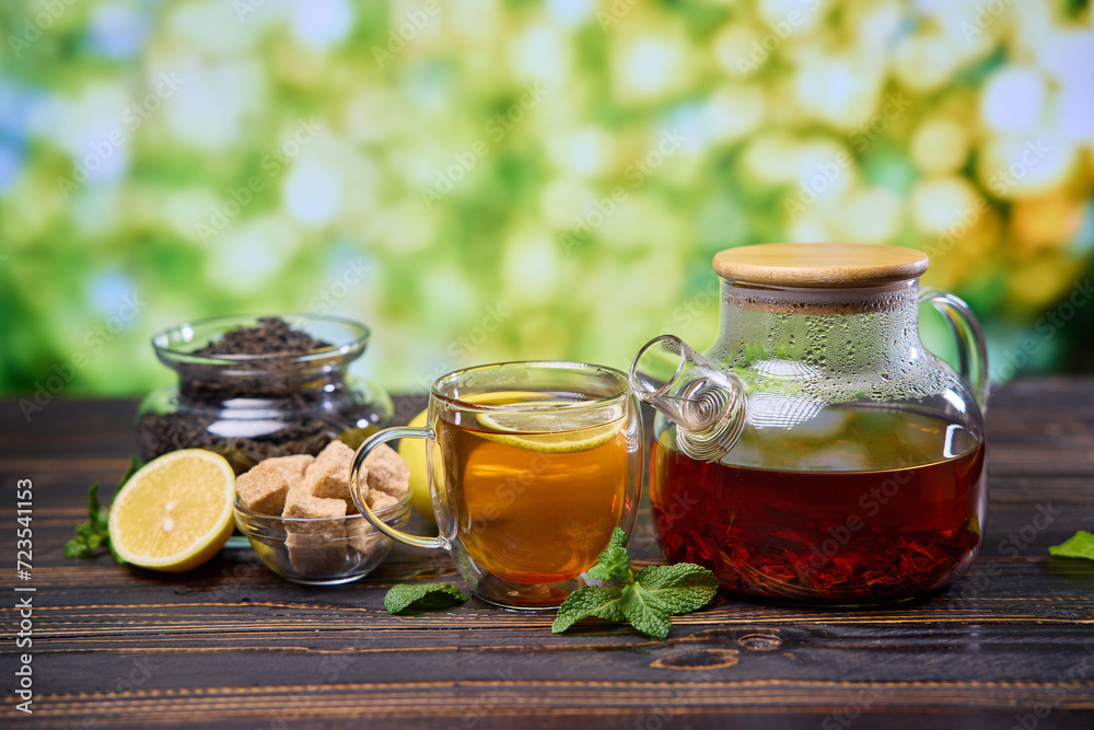 natural organic herbal tea in glass teapot and cup on a wooden table natural organic herbal tea in glass teapot and cup on a wooden table