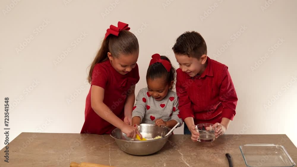 Niños felices mezclando ingredientes para hornear y cocinar galletas en el día del amor y la amistad para compartir juntos con su familia delicioso postre