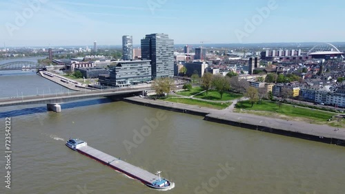 Aerial cityscape of industrial ship on urban river with glass corporate buildings in background, Cologne photo