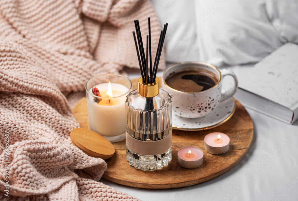 Bamboo sticks in bottle with scented candles and cup of coffee Bamboo sticks in bottle with scented candles and cup of coffee