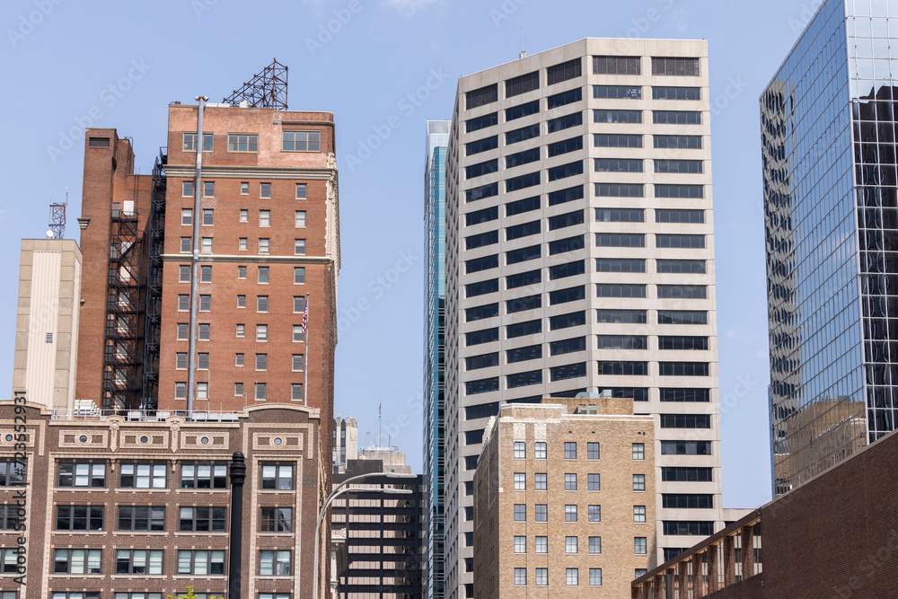 Naklejka premium Kansas City, Missouri, USA - June 15, 2023: Afternoon light shines on historic buildings in downtown Kansas City.