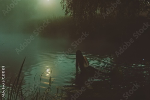 Mermaid bathes in the lake at dawn.
