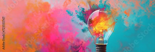 Creative light bulb explodes with colorful paint and colors. New idea, brainstorming concept. Bright banner with splashes photo