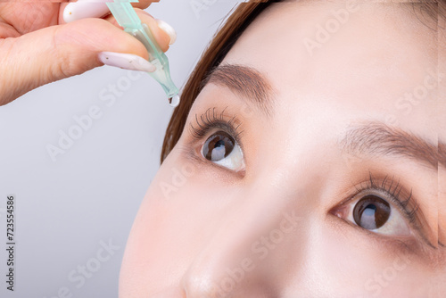 фотографія 目薬をさす女性　woman applying eye drops