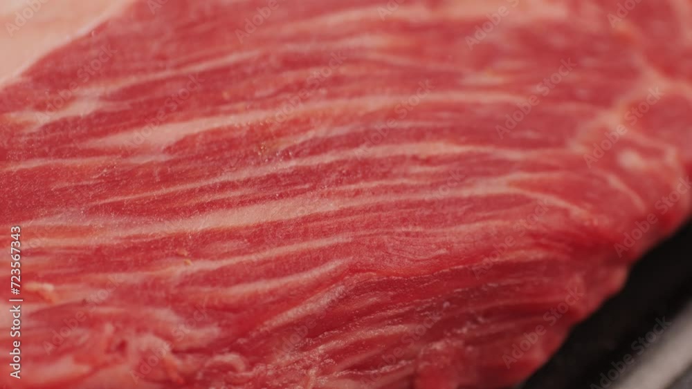 Fresh marbled beef with pepper, salt and rosemary close-up macro. Preparation to cook juicy steak on grill. Premium organic raw wagyu meat Fresh marbled beef with pepper, salt and rosemary close-up macro. Preparation to cook juicy steak on grill. Premium organic raw wagyu meat
