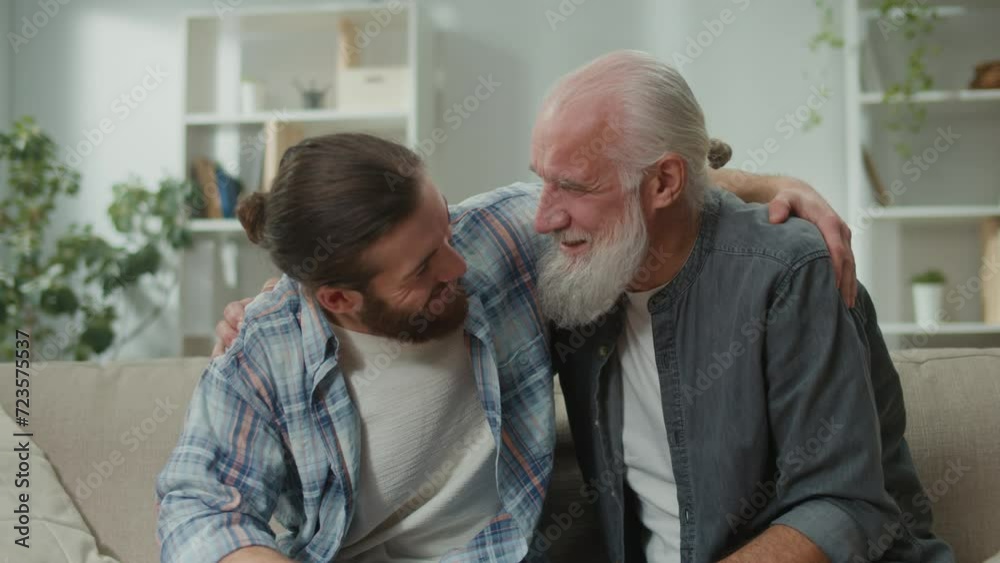 Young and elderly men share life experiences, sitting on a couch, discussing personal stories, psychological support, cross-generational understanding, heart-to-heart talks, family communication Young and elderly men share life experiences, sitting on a couch, discussing personal stories, psychological support, cross-generational understanding, heart-to-heart talks, family communication