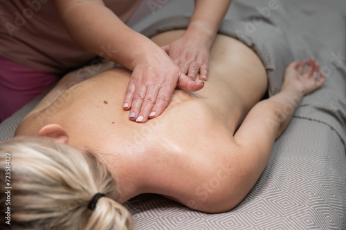 Woman having a manual back massage session. Close-up. 