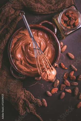 Chocolate cream cheese mousse in a bowl with whisk, preparing healthy homemade sugar free snack