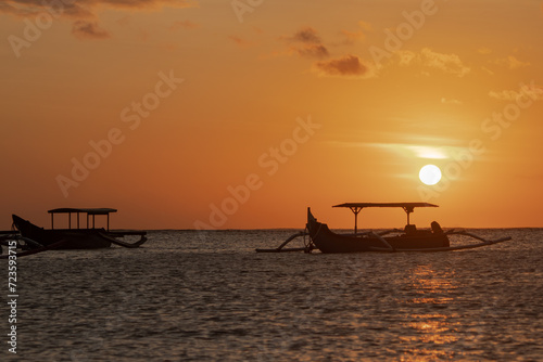 sunset on german beach, kuta bali, with beautiful sunset views and fishing boats in the background ( Pantai Jerman Bali sunset)