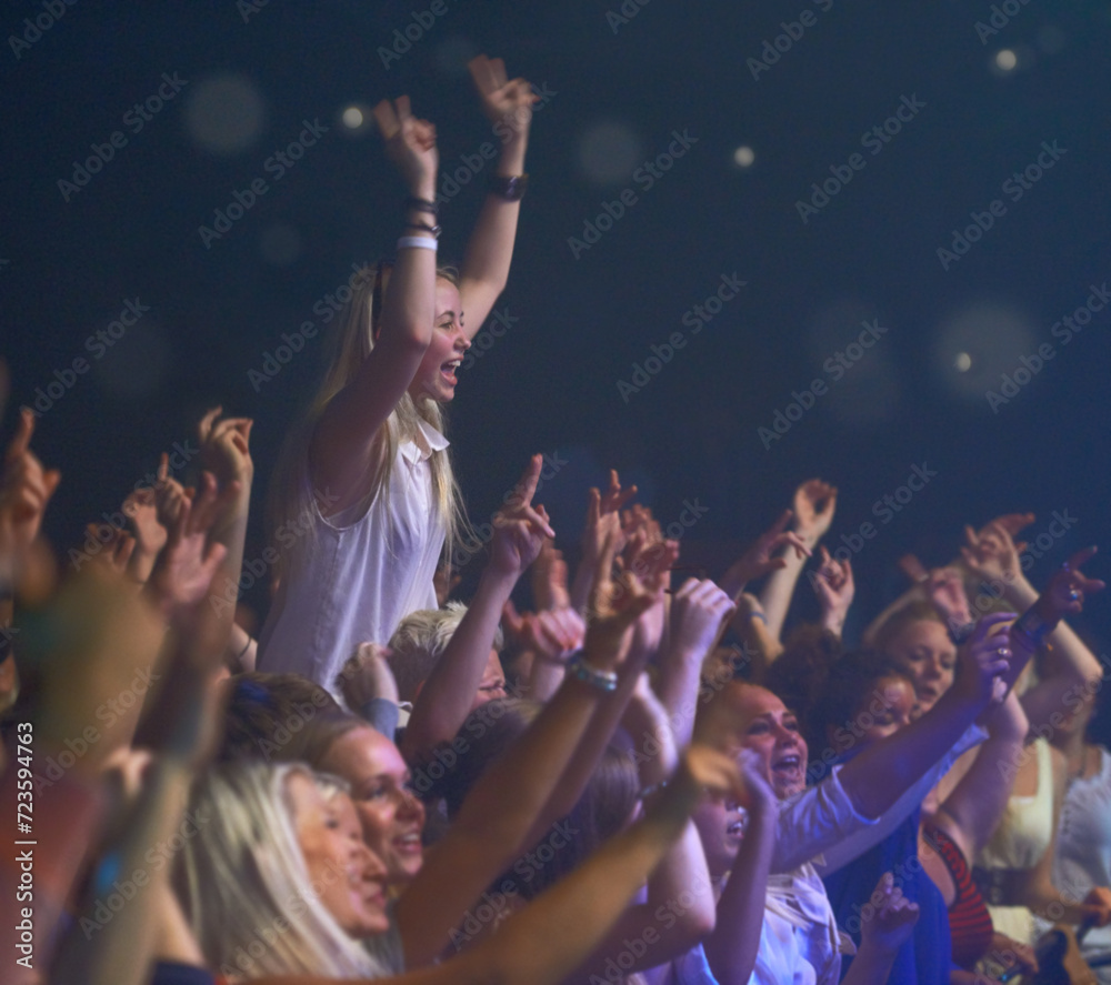 Concert, audience and music with happy woman in group at dj, band and festival event at a stage with lights. Rock show, dance and party with excited crowd with rave, techno and entertainment at venue Concert, audience and music with happy woman in group at dj, band and festival event at a stage with lights. Rock show, dance and party with excited crowd with rave, techno and entertainment at venue