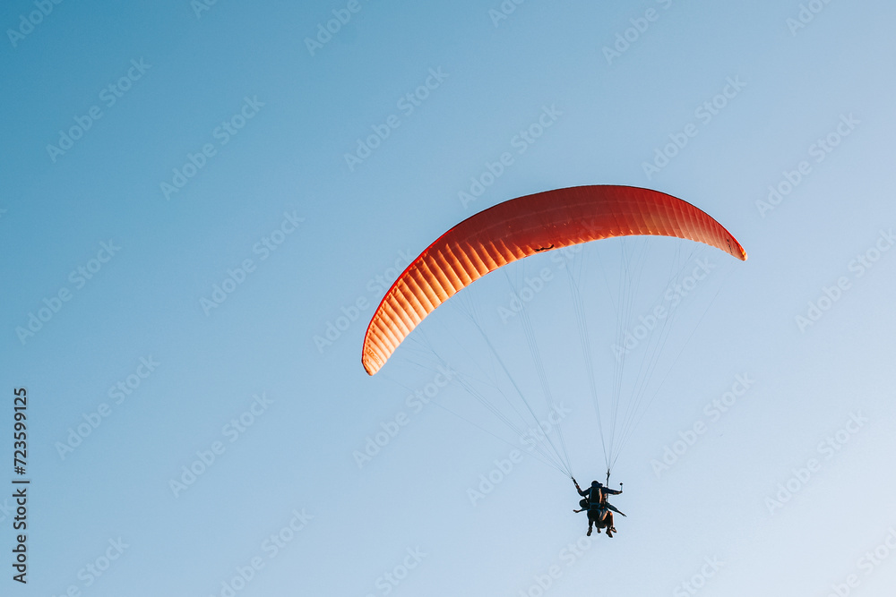 Paraglider flying over the blue sky. Concept of extreme sport, taking adventure challenge. Paraglider flying over the blue sky. Concept of extreme sport, taking adventure challenge.