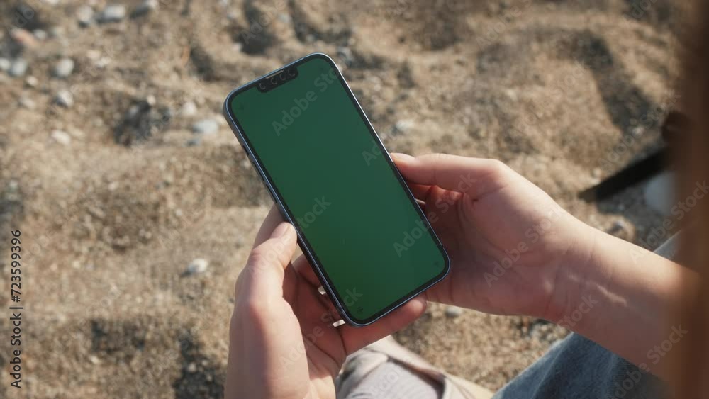 Green Screen chroma key Handheld Smartphone. Travel with phone concept, application mock up. Sunset on a tropical beach.