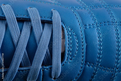 Part of a blue leather lace-up sneaker close-up. Shoe leather close-up.