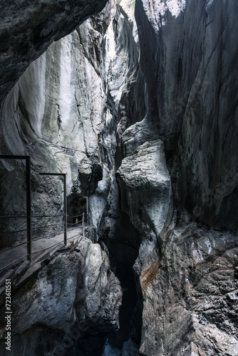 Natural limestone cave in the canyon and pathway in Rosenlaui glacier gorge at Switzerland