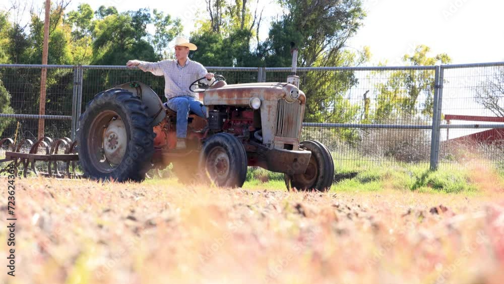 Cowboy Looking Over the Land on Tractor Harrowing Pasture Cowboy Looking Over the Land on Tractor Harrowing Pasture
