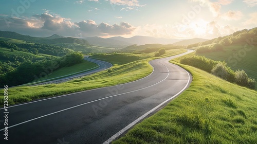 A sleek modern highway curving gracefully through a lush green landscape at sunset photo