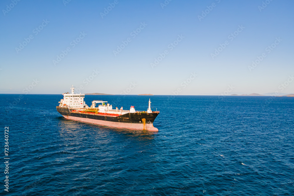 Petrochemical product cargo ship at anchorage in sea before loading on industrial terminal. Aerial view