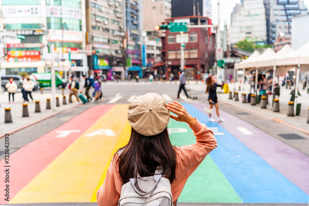 Naklejka premium Young female tourist with Rainbow Road crossing at Ximending landmark and popular attractions in Taipei, Taiwan