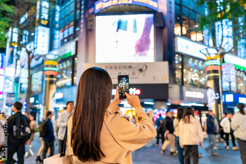 Young female tourist taking a photo of the Ximending shopping street landmark and popular attractions in Taipei  Taiwan