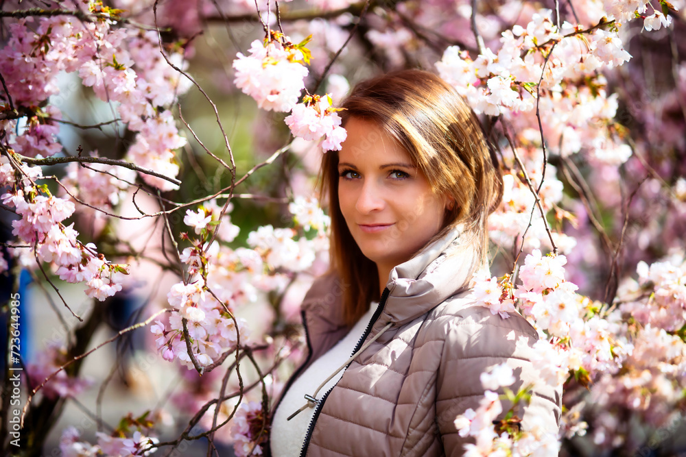 Young woman in her mid-thirties, head portrait in front of blooming cherry blossoms. Young woman in her mid-thirties, head portrait in front of blooming cherry blossoms.