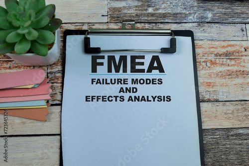 Concept of FMEA - Failure Modes and Effects Analysis write on paperwork isolated on wooden background. photo