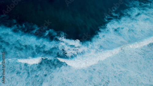 Turquoise ocean sea water white wave pattern splashing deep blue sea. Seascape dark ocean background wave splash on rock. Tropical sea beach in summer seaside outdoor. Water Surface blue wave pattern