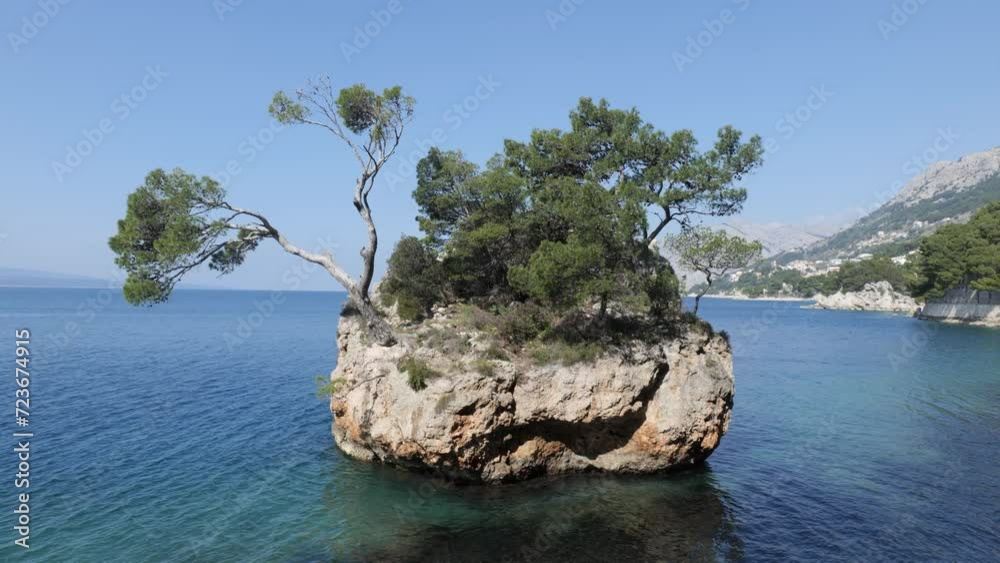 The symbol of Brela, The Brela Stone. This rock in the sea, overgrown with pines, shows the strength and power of survival and growth from the stone itself. Natural beauty. The symbol of Brela, The Brela Stone. This rock in the sea, overgrown with pines, shows the strength and power of survival and growth from the stone itself. Natural beauty.