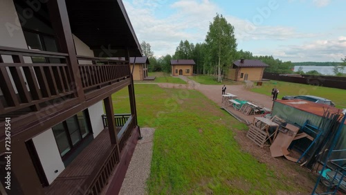 New country houses in a picturesque cottage community. Flight over a metal double-slope metal tile roof. Aerial FPV drone shot.