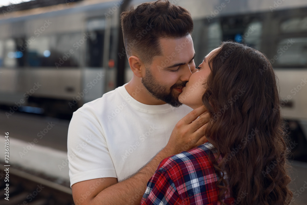 Long-distance relationship. Beautiful couple kissing on platform of railway station Long-distance relationship. Beautiful couple kissing on platform of railway station