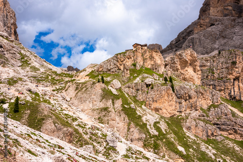 Dolomite alps and a house or mountain refuge on rock above