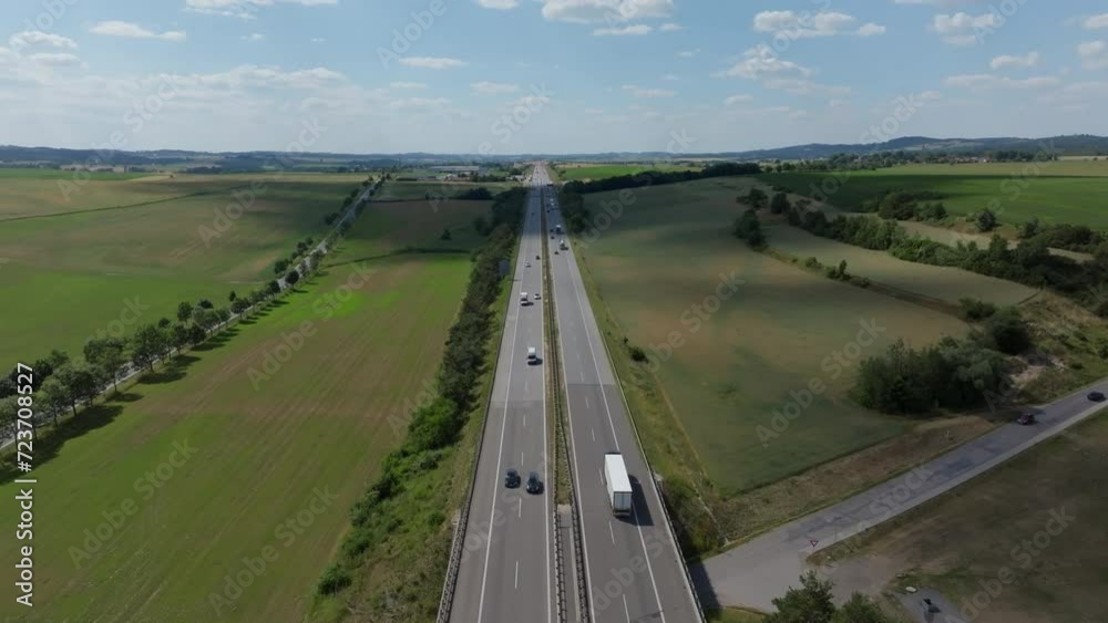 Drone advances over a bustling four-lane Austrian autobahn, capturing the summer traffic scene Drone advances over a bustling four-lane Austrian autobahn, capturing the summer traffic scene