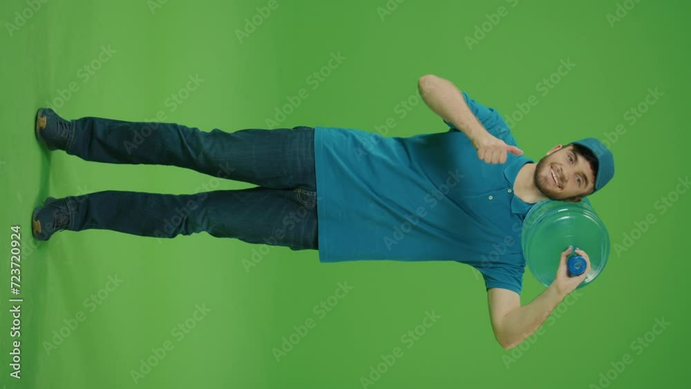 Vertical Video Green Screen Portrait of a Delivery Person in Uniform Holds a Big Bottle of Water and Smiles. Courier Working in Logistics Distribution Center, Delivering Online Orders. Vertical Video Green Screen Portrait of a Delivery Person in Uniform Holds a Big Bottle of Water and Smiles. Courier Working in Logistics Distribution Center, Delivering Online Orders.
